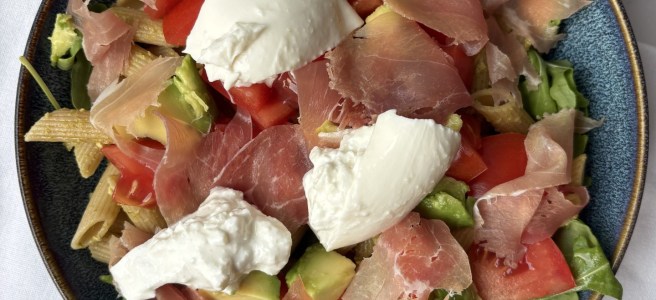 Pastasalade met burrata en prosciutto.