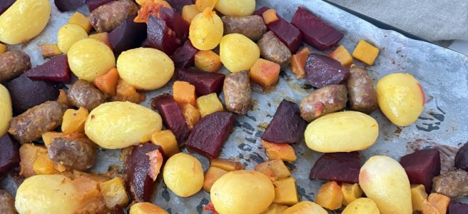 Traybake pompoen rode biet krieltjes en chipolata.