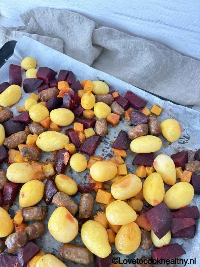 Traybake pompoen rode biet krieltjes en chipolata.